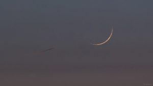 Flugzeug und schmale Mondsichel am 7. Juni 2024